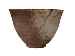 A piece of pottery that broke, was repaired with gold, and is now Kintsukoroi. Do you see the Rune symbol?(Image shared on a Kintsukoroi post on Camiimac.)